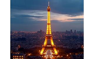 Vue nocturne illuminée de Paris avec la Tour Eiffel en arrière-plan.